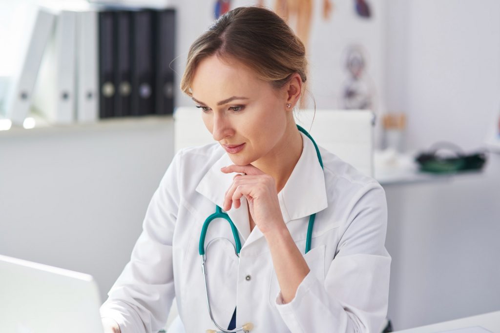 Doctor using her laptop to transcribe what she speaks about with her patients