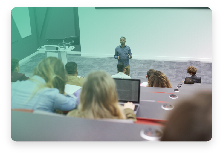 Lecture being presented by a man standing in front of the sitting university students