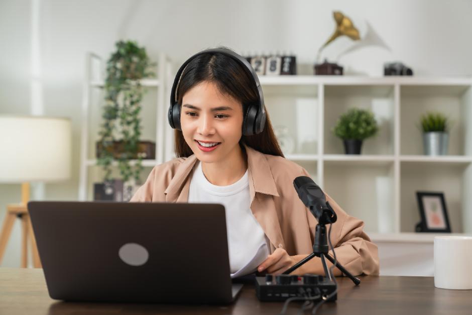 woman wearing headphones and using laptop to transcribe audio to text