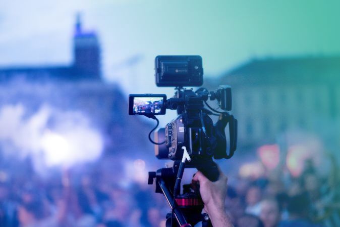 Big camera recording a mass event at dawn outside