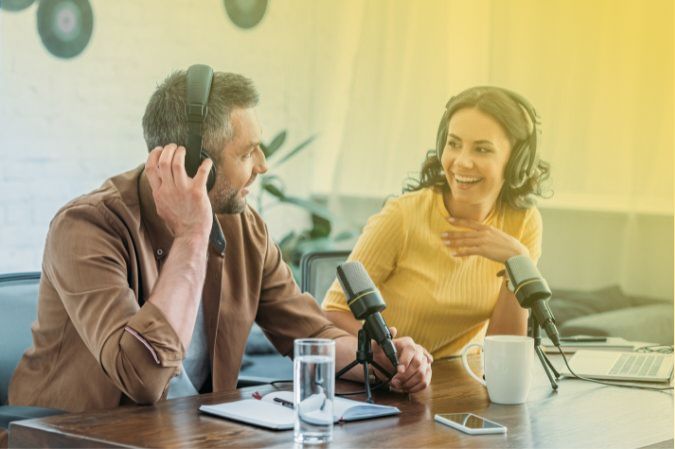 Two people talking on a podcast in a studio