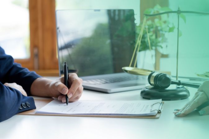 Man in suit signing a contract in an office