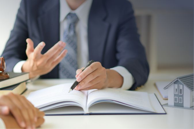 Man discussing business in an office at a desk above a notebook