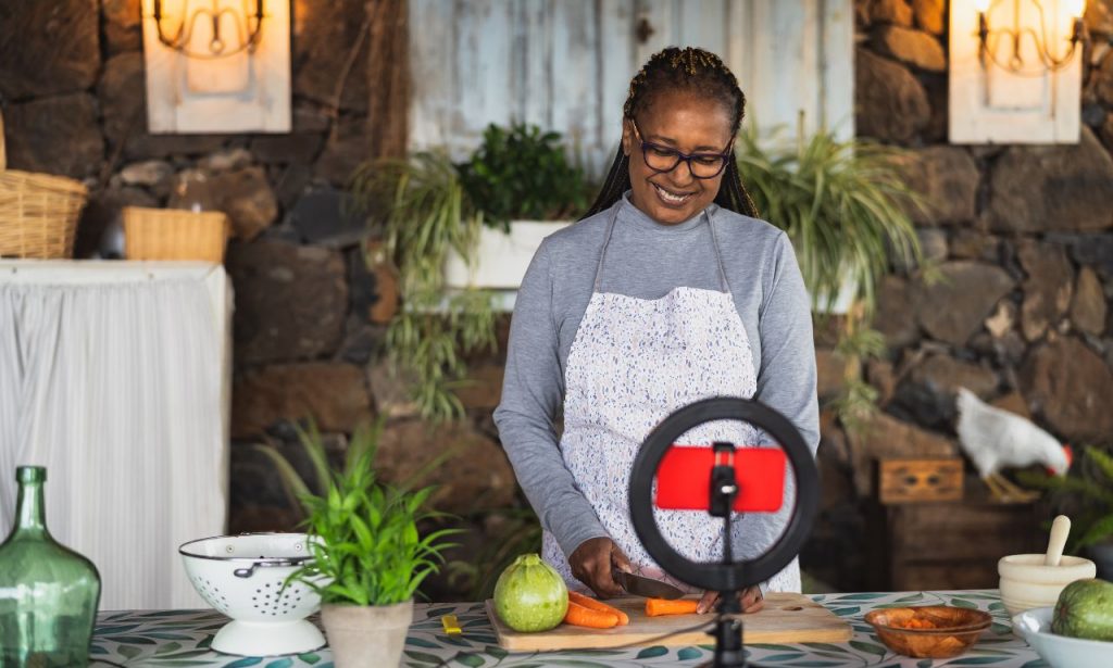 African American woman creating a cooking video for her social media platform and then adding captions to it to increase the engagement from viewers