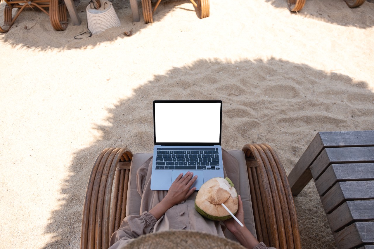 Lady sitting at the beach while doing remote job