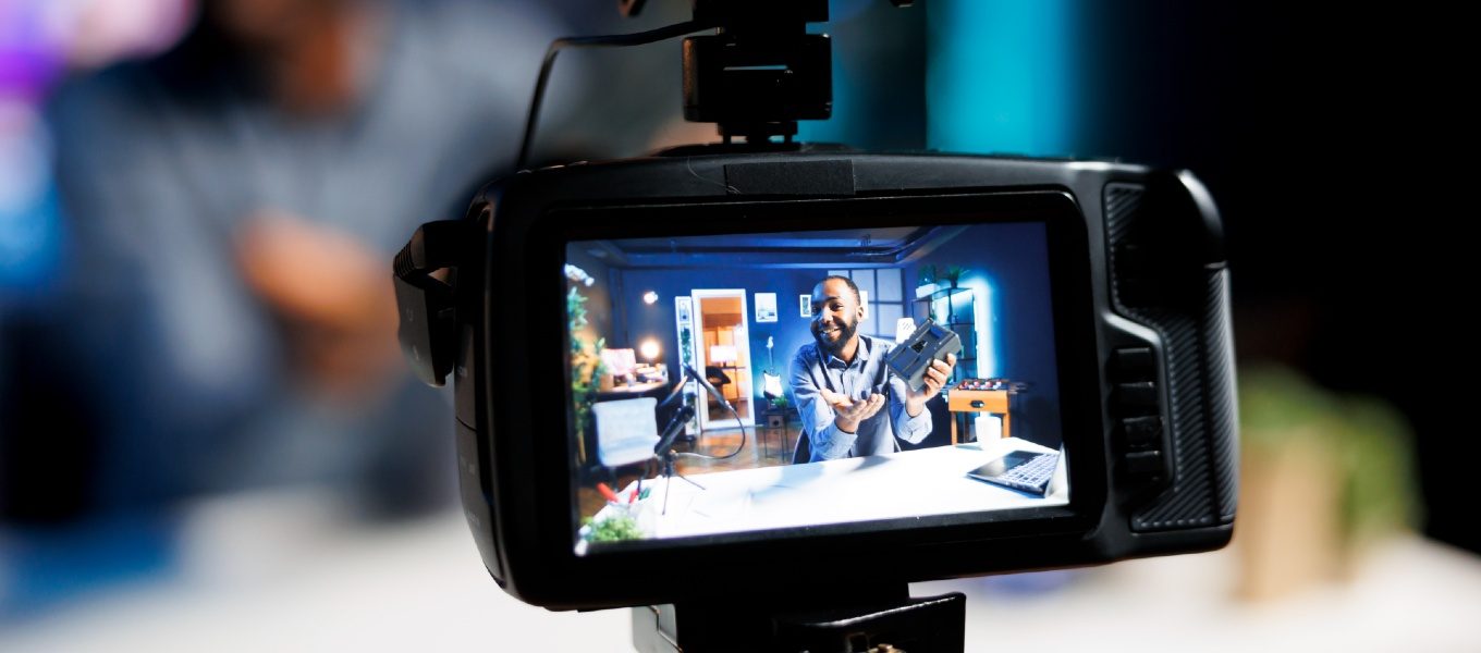 closeup of a camera on which a man is crerating online content